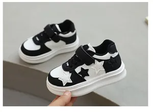 Detail view of black and white children's sneakers with star patterns and velcro strap