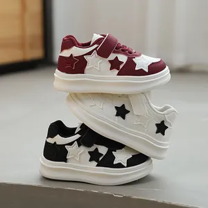 Stack of children's sneakers with star pattern in burgundy, white, and black colors