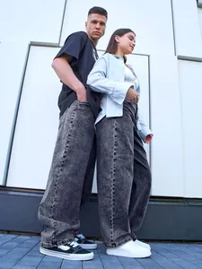 Detail view of oversized gray acid-wash wide-leg denim jeans for men on a street model