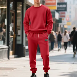 Lifestyle view of a man in a red heavy fleece crewneck sweatshirt and joggers set