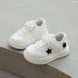 Children's white sports sneakers with black star patterns and Velcro straps