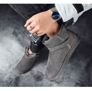 Close-up detail of grey suede snow boots with warm faux fur lining worn by a model.