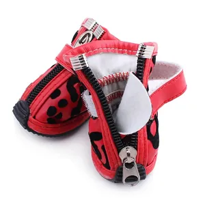 Detail showing red leopard print dog boots with zipper closure and soft flocking texture