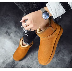 Close-up of winter suede leather snow boots with warm fur lining worn by model.
