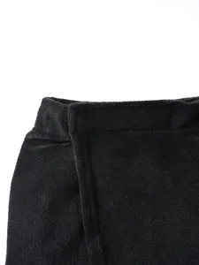 Close-up of black wearable bath towel showing soft terry cloth texture and waist closure