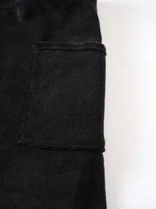 Detail of soft black terry cloth wearable bathrobe with functional side pocket.
