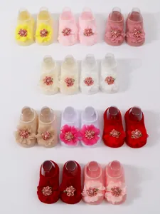 Detalle de calcetines de suelo para bebé con grandes flores de malla 3D en varios colores
