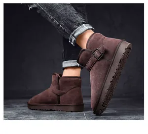 Detailed view of brown suede winter snow boots with buckle design and textured sole.
