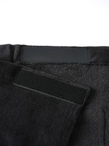 Close-up detail of the adjustable magic tape fastener on black plush wearable bath towel