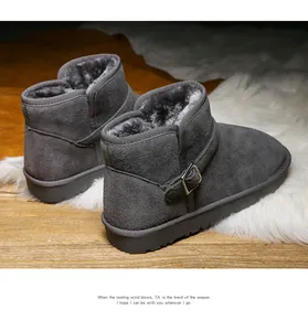 Detail view of grey suede leather snow boots with thick faux fur lining and metal buckle