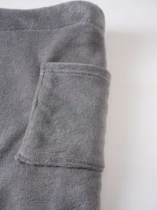 Close-up of grey plush bathrobe detail showing soft flannel texture and functional pocket