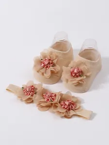 Primer plano de calcetines para bebé y diadema floral en malla color albaricoque