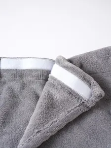 Close-up detail of the white Velcro closure on a plush gray men's wearable bathrobe.