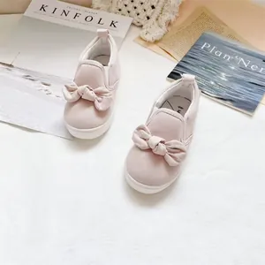 Λεπτομέρεια από ροζ πάνινα παπούτσια slip-on για παιδιά με διακοσμητικό σχέδιο φιόγκου