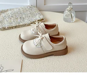 Elegant beige girl's princess shoes with bow and lace detail on textured background