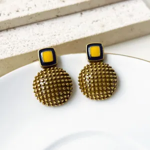Primer plano de pendientes vintage de esmalte con base redonda texturizzata en relieve