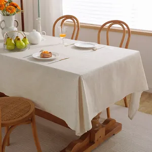 Detailed texture of a minimalist plain cotton linen tablecloth on a wooden dining table
