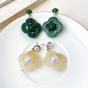Gros plan détaillé des boucles d'oreilles vintage françaises en malachite et perles.