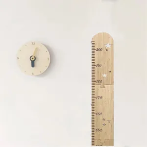 Wooden height growth chart detail showing star cutouts and clear scale numbers on white wall.