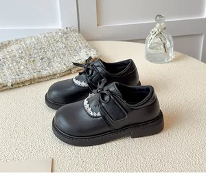 Detail view of black girls' princess shoes with sweet bow and lace scalloped trim