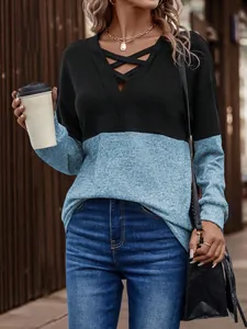 Detalle de la camiseta de cuello en V bicolor con tiras cruzadas y ajuste casual.