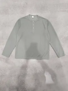 Detailaufnahme eines olivgrünen Herren-Henley-Shirts mit gerippter Struktur und Knöpfen