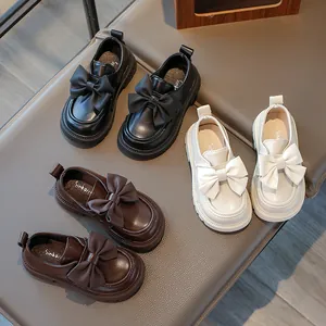 Detailed view of girls' leather princess shoes with bows in black, cream, and brown colors
