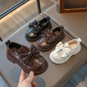 Detailed view of stylish girls' bow-knot leather loafers in black, brown, and white colors