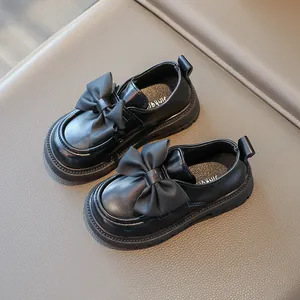Close-up of black girls' princess loafers featuring a decorative bow and soft sole detail.