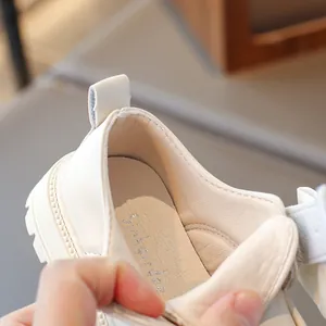 Close-up of soft interior lining and padded insole of girl's beige leather loafers.