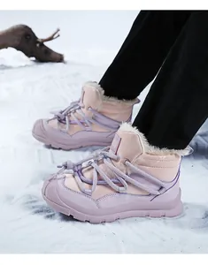 Close-up view of children's pink and purple snow boots with warm fur lining on snow