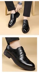 Detail of black crocodile pattern leather dress shoes with classic brogue carving