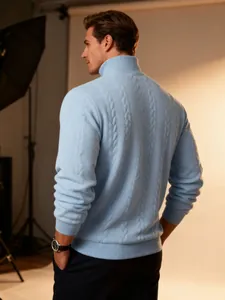Close-up back view of a men's light blue turtleneck cable-knit sweater in warm studio light