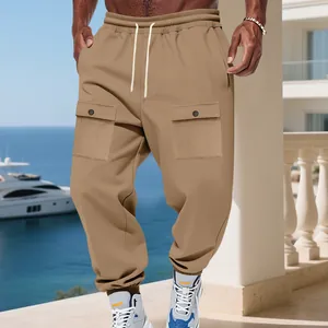 Pantaloni cargo da uomo kaki eleganti con coulisse e tasche su una terrazza soleggiata.