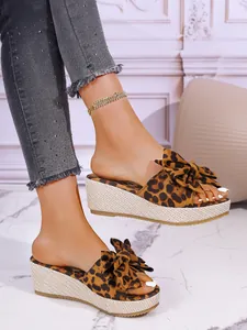 Stylish leopard print wedge sandals with bow detail for women in summer fashion look.