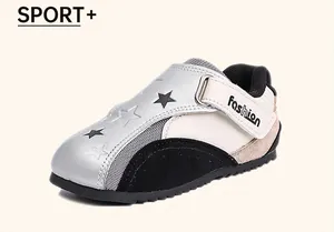 Detailed side view of girls' silver and cream star-patterned sneakers with velcro strap