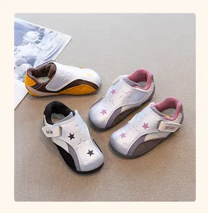 Close-up detail of children's German army trainer sneakers featuring cute star patterns.