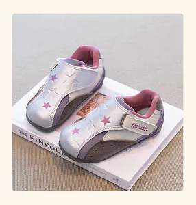 Detailed side view of girls' silver and pink German trainer style sneakers with star patterns