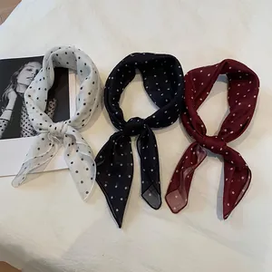 Trois foulards carrés en coton et lin à pois, noués, en blanc, bleu marine et bordeaux.