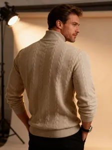 Detailed macro view of the intricate beige cable-knit texture on men's high neck sweater
