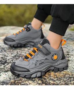 Primo piano di scarpe da trekking grigie e arancioni per bambini con motivi montani