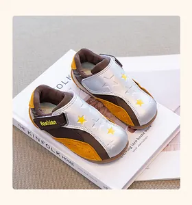 Close-up detail of stylish silver and brown girls' German trainer sneakers for autumn season
