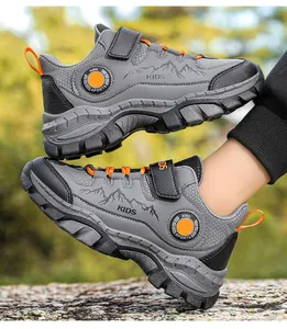 Vista laterale di scarpe da trekking grigie per bambini con grafiche montane e dettagli arancio