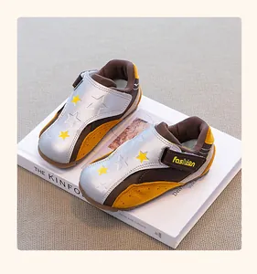 Close-up of silver and brown girls' GAT sneakers with star patterns and velcro straps