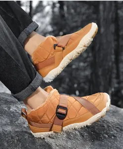 Detail of tan outdoor fleece-lined snow boots with adjustable buckle strap on a rock.