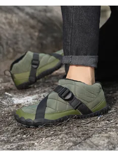 Detail view of green quilted outdoor snow boots with black buckle straps and fleece lining.
