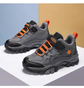 Vista dettagliata di scarpe da trekking per bambini grigie e arancioni con suole.