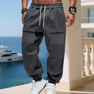 Dettaglio di pantaloni della tuta cargo grigio scuro con ampie tasche laterali.