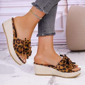 Fashion leopard print wedge slide sandals with bow detail and woven platform sole.