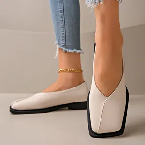 Détail de mocassins crème à bout carré avec une couture en V caractéristique